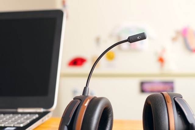 A headset next to a laptop, representing ways of choosing a help desk software solution